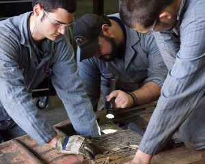 A group of diesel tech students work together on an enginer repair in the diesel classroom.