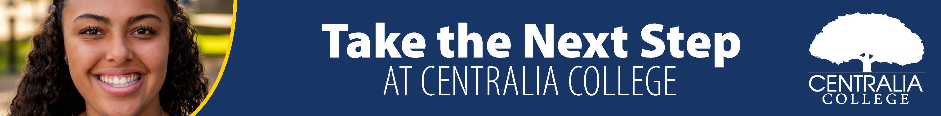 A smiling Centralia College stands on campus with a blue banner that reads "Take the next step at Centralia College" in white letters