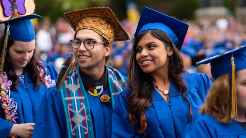 Two Centralia College graduates smile and post together at the commencement ceremony.